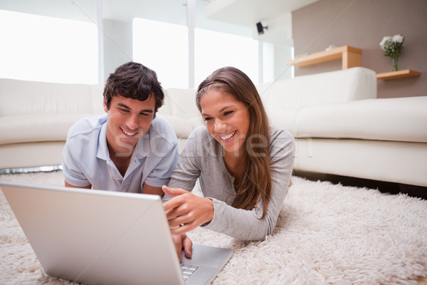 Stock photo: Young couple with notebook on the floor