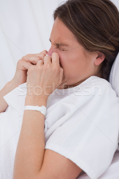 Side view of woman in hospital bed sneezing Stock photo © wavebreak_media