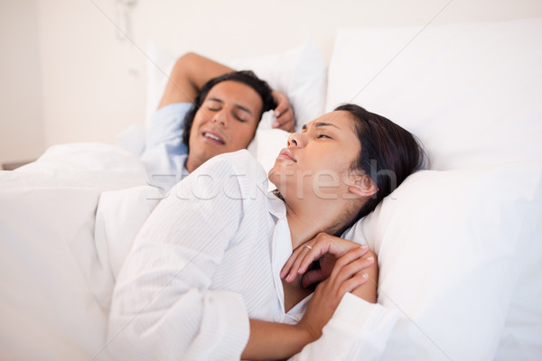 Stock photo: Young woman being woken up by snoring boyfriend