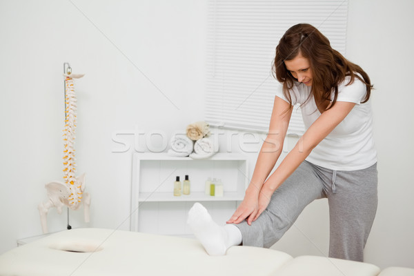 Serious brunette woman stretching her body in a medical room Stock photo © wavebreak_media