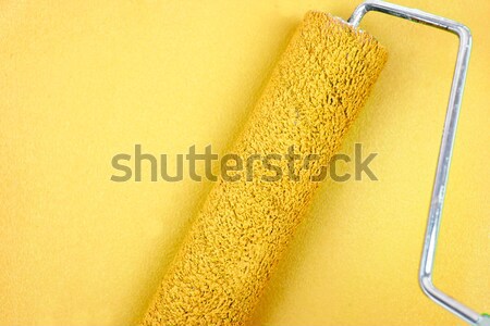 Yellow background with a paint roller in the middle Stock photo © wavebreak_media