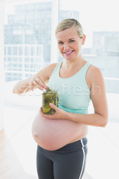 Glimlachend blond zwangere vrouw eten jar augurken Stockfoto © wavebreak_media