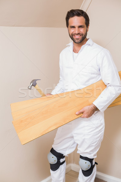 Carpenter holding planks and hammer Stock photo © wavebreak_media