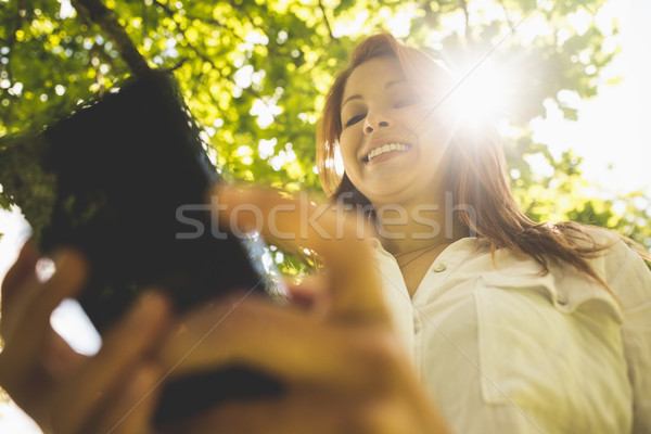 Csinos vörös hajú nő sms üzenetküldés telefon park napos idő Stock fotó © wavebreak_media