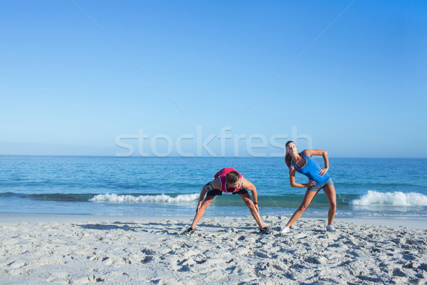 Happy couple stretching together beside the water Stock photo © wavebreak_media
