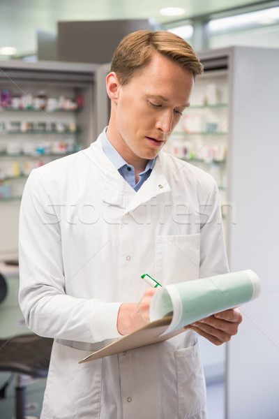 Focused pharmacist writing on clipboard Stock photo © wavebreak_media