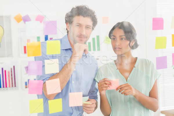  Puzzled business team looking post its on the wall Stock photo © wavebreak_media