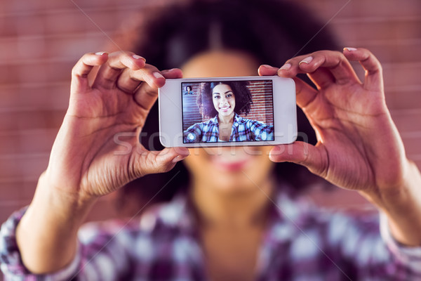 Attractive young woman taking selfies with smartphone Stock photo © wavebreak_media