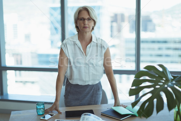 Portrait of businesswoman standing by desk Stock photo © wavebreak_media