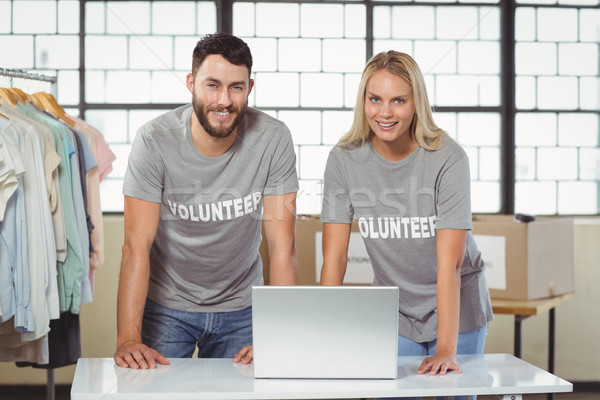Portrait of smiling volunteers working on laptop Stock photo © wavebreak_media