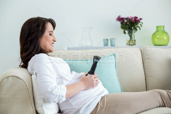 Terhes nő tart fejhallgató has nappali nő Stock fotó © wavebreak_media