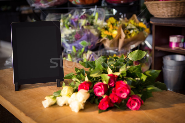 Bunch of roses and digital tablet on the wooden table Stock photo © wavebreak_media