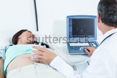 Female doctor explaining sonography report to patient on screen Stock photo © wavebreak_media