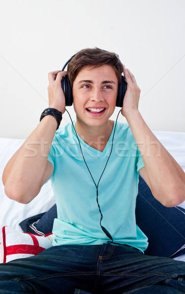 A teenage guy sitting on his bed listening to the music Stock photo © wavebreak_media