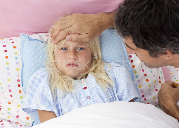 Father taking his daughter's temperature in bed Stock photo © wavebreak_media