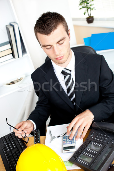 Serious young businessman using his calculator in the office Stock photo © wavebreak_media