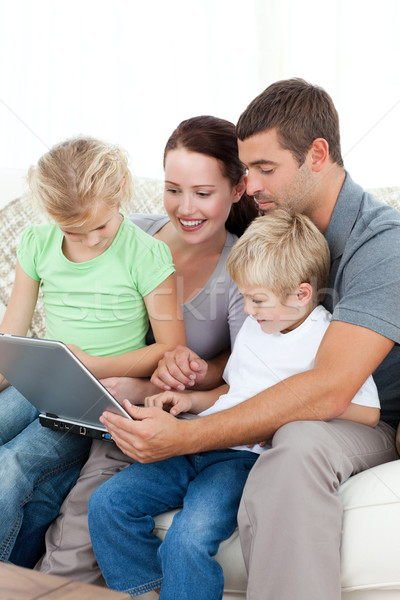 [[stock_photo]]: Parents · enfants · utilisant · un · ordinateur · portable · ensemble · séance · canapé