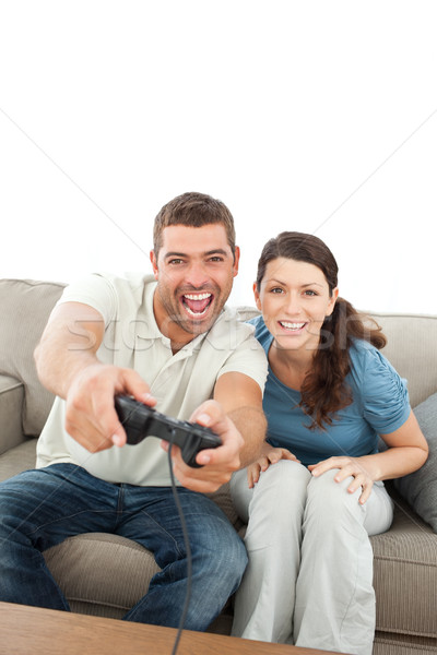 Happy couple playing video games together sitting on the sofa Stock photo © wavebreak_media
