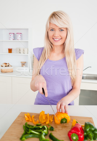 Beautiful blonde woman cutting peppers in modern kitchen interior in her appartment Stock photo © wavebreak_media