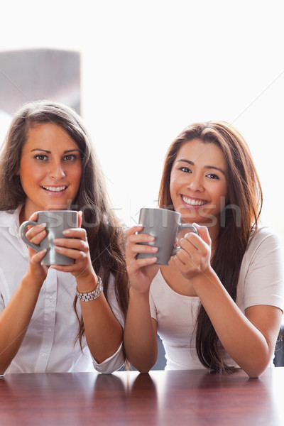 Portrait of friends having a cup of coffee while smiling at the camera Stock photo © wavebreak_media