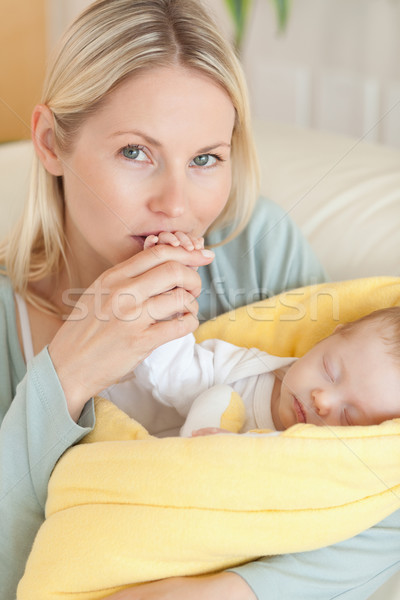 Stock photo: Close up of affectionate young mother kissing her baby's hand