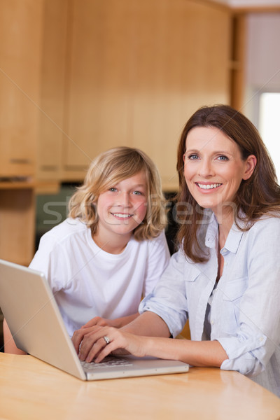 Stock photo: Mother and her son with laptop in the kitchen