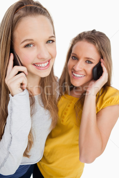 Közelkép kettő diákok mosolyog telefon fehér Stock fotó © wavebreak_media