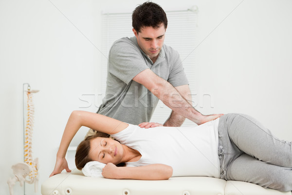 Osteopath crossing his arms while massaging a woman in his medical office Stock photo © wavebreak_media
