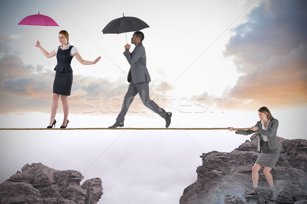 Young businesswoman pulling a tightrope for business people Stock photo © wavebreak_media