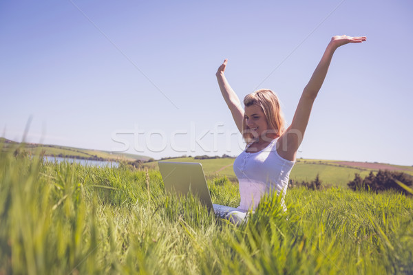 Csinos szőke nő ül fű laptopot használ éljenez Stock fotó © wavebreak_media