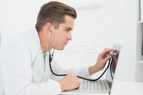 Technician listening to laptop with stethoscope Stock photo © wavebreak_media