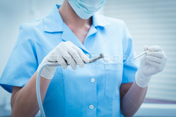 Mid section of dentist holding dental tools Stock photo © wavebreak_media