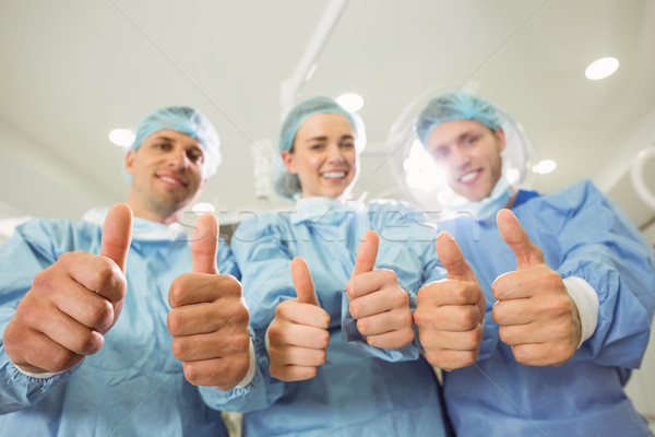 Team of surgeons looking at camera showing thumbs up Stock photo © wavebreak_media