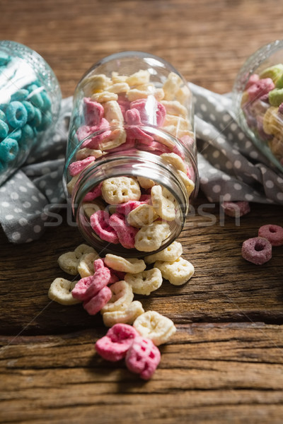 Scattered honeycomb cereals from jar on wooden table Stock photo © wavebreak_media