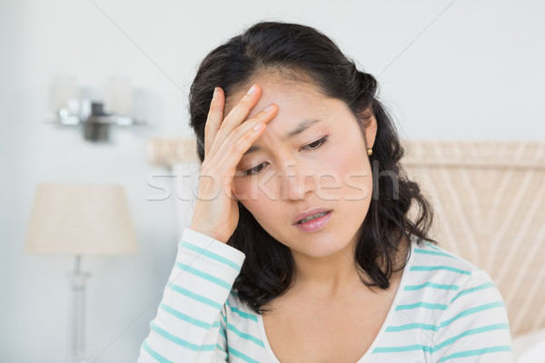 Woman with head ache sitting on bed Stock photo © wavebreak_media