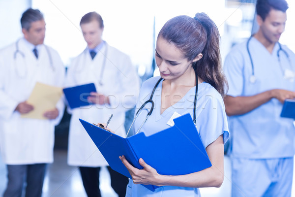 Femeie medic scris medical raportează colegii Imagine de stoc © wavebreak_media