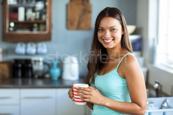 Portrait of smiling young woman holding coffee cup Stock photo © wavebreak_media