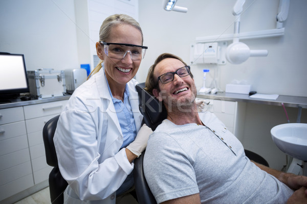 Female dentist and male patient smiling Stock photo © wavebreak_media