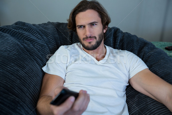 Man changing a channel while watching tv in living room Stock photo © wavebreak_media