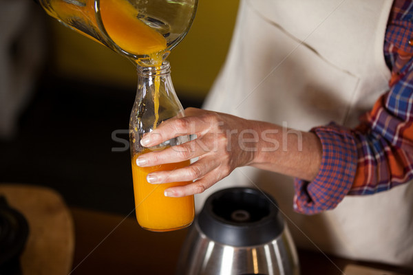 Female staff pouring juice in a bottle Stock photo © wavebreak_media