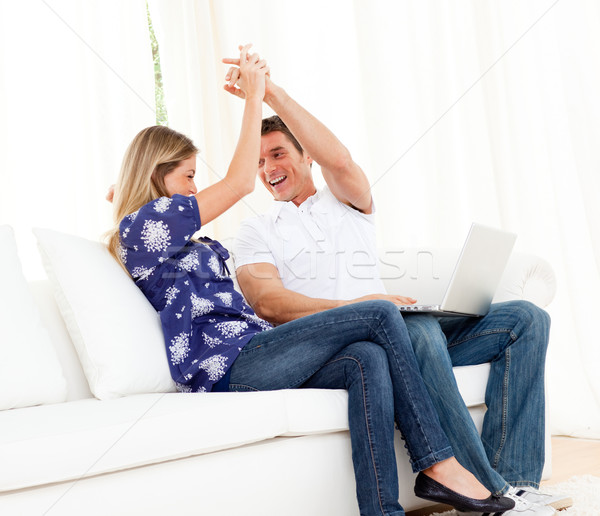 Animado Pareja usando la computadora portátil sesión sofá casa Foto stock © wavebreak_media