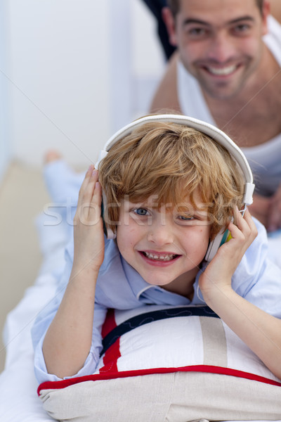 Son listening to music in bed with his father Stock photo © wavebreak_media