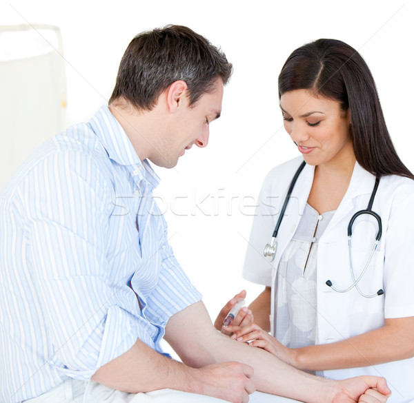 Radiant female doctor making injection to her patient against white back ground Stock photo © wavebreak_media