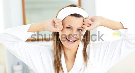 Beautiful woman stretching while standing in the bathroom wearing a bath robe Stock photo © wavebreak_media