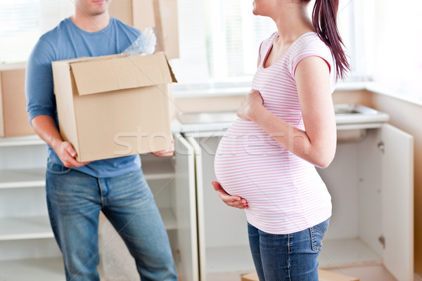 Close-up of a pregnant woman talking to her husband who is holding a cardboard in their new house Stock photo © wavebreak_media