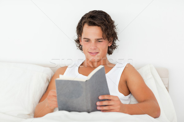 Przystojny mężczyzna czytania książki sypialni domu szczęśliwy Zdjęcia stock © wavebreak_media