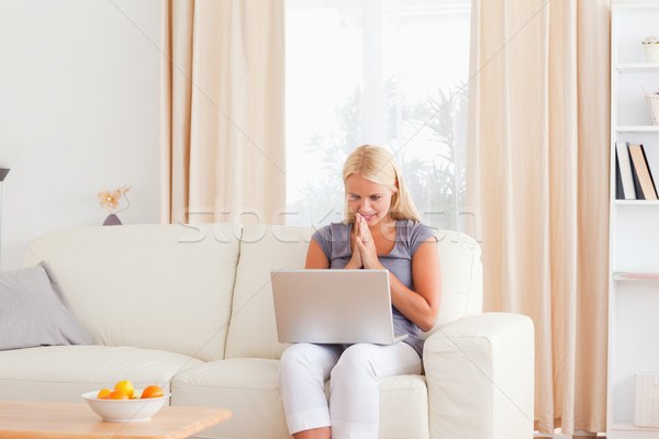 Foto stock: Preocupado · mulher · usando · laptop · sala · de · estar · mão · sorrir