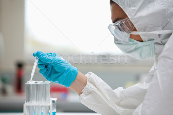 Close up of a protected female scientist dropping liquid in a test tube in a laboratory Stock photo © wavebreak_media
