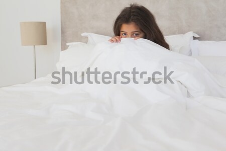 Young woman stretching her arms and yawning in her bedroom Stock photo © wavebreak_media