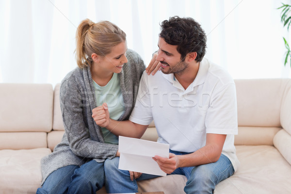 Happy couple reading a letter in their living room Stock photo © wavebreak_media